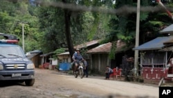 Warga setempat mengayuh sepeda motornya melewati pos polisi di Maungdaw, kota perbatasan di negara bagian Rakhine, Myanmar (Foto: dok). Para aktivis pendukung Rohingya melaporkan lebih darii 100 anggota komunitas muslim tersebut tewas dalam aksi kontra pemberontakan di negara bagian Rakhine baru-baru ini.