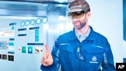FILE - In this image released Sept. 15, 2016, German elevator maker Thyssenkrupp uses Microsoft HoloLens technology in its elevator service operations.