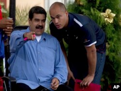 Venezuela's President Nicolas Maduro, left, speaks with Congressman Hector Rodriguez during a meeting with students outside of Miraflores Presidential Palace to mark national Student Day in Caracas, Venezuela, Nov. 21, 2016.