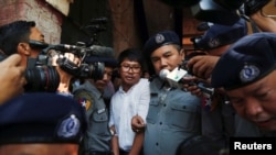 Detained Reuters journalist Wa Lone escorted by police after a court hearing in Yangon, Myanmar February 6, 2018. REUTERS/Stringer