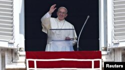 Pope Francis waves as he leads the Angelus prayer from the window of the Apostolic palace in Saint Peter's Square at the Vatican, Aug. 9, 2015.