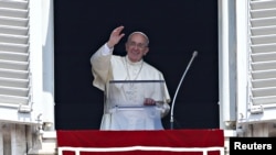 FILE - Pope Francis waves as he leads the Angelus prayer from the window of the Apostolic palace in Saint Peter's Square at the Vatican, Aug. 9, 2015.