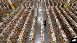 Pegawai Amazon.com menyusun persediaan barang di salah satu dari banyak lorong penyimpanan di Pusat Persediaan Barang di Phoenix, Arizona, pada hari tersibuk belanja online di musim belanja liburan, "Cyber Monday," Desember 2013.