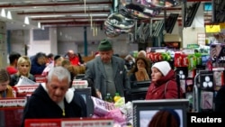 People stand at the checkout line in a supermarket in Jerusalem, Jan. 6, 2015. 
