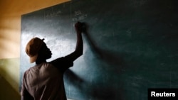 A student writes on a blackboard in a classroom at the Loyola Cultural Center in Agoe-Nyive, a suburb of Lome, April 15, 2013.