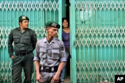 Polisi Syariah berjaga di depan restoran, yang buka untuk melayani pelanggan non-Muslim, untuk menjaga agar konsumen Muslim tidak makan di restoran tersebut selama bulan Ramadan, di Banda Aceh, 1 Juli 2014.