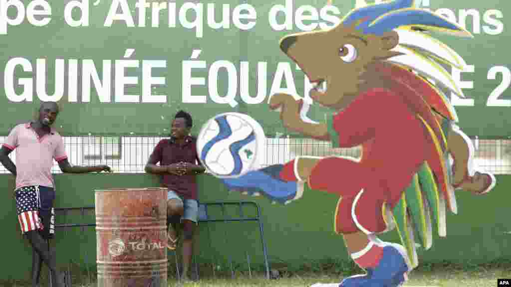 Des hommes non identifiés sont debout devant un kioske de vente de&nbsp;billets avant le match d&#39;ouverture du groupe A de la Coupe d&#39;Afrique des Nations de football à Bata, en Guinée équatoriale, le vendredi 16 janvier 2015.
