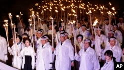 韩国人穿着传统服装，举着火把，参加庆祝3月1日独立日游行（2017年3月1日）