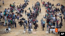 难民与移民在希腊莱斯博斯岛的一个足球场等候登记与发放旅行文件(2015年9月8日)