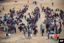 Refugees and migrants wait for their registration and the issuing of travel documents at a soccer stadium in Mytilene, on the northeastern Greek island of Lesbos, Sept. 8, 2015.