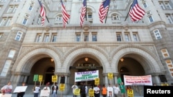Des manifestants se tiennent à l'extérieur du Trump International Hotel qui a ouvert ses portes lundi 12 septembre 2016, à Washington D.C.