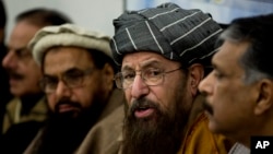 FILE - Pakistani religious cleric, Sami-ul-Haq, second right, addresses a news conference with, Hameed Gul, former chief of Pakistan's intelligence, left, in Islamabad, Pakistan.