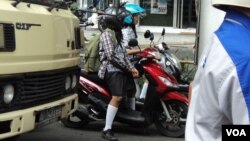 Pelajar SMP di Solo mengendarai sepeda motor ke sekolah. (VOA/Yudha Satriawan)