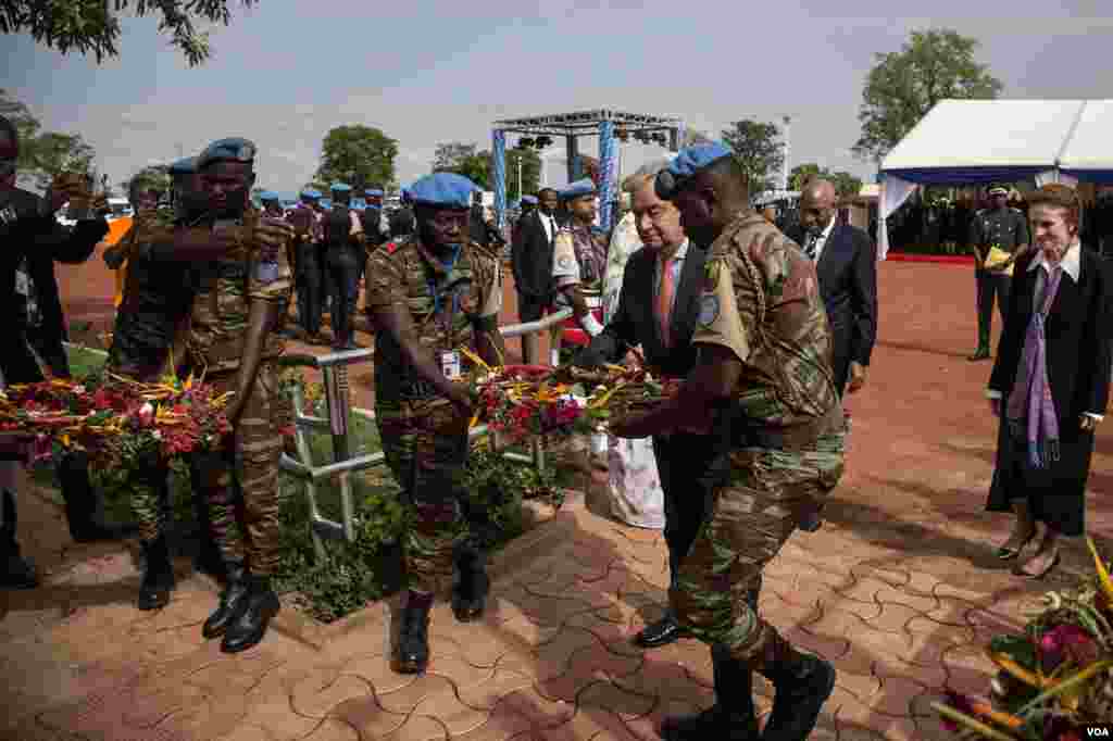 Le secrétaire général de l'ONU, Antonio Guterres, au milieu de deux casques bleus, déposent une gerbe de fleurs en mémoire des soldats onusiens décédés au Mali, 30 mai 2018. (VOA/Kassim Traoré)
