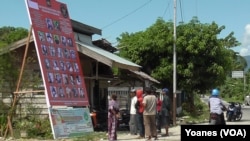 Warga masyarakat di dusun Ratolene, Kelurahan Kasiguncu, Kecamatan Poso Pesisir Utara mengamati daftar DPO Kelompok Santoso (VOA/Yoanes).