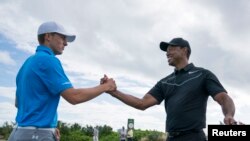 Tiger Woods (kanan) berjabat tangan dengan Jordan Spieth dalam latihan menjelang turnamen Hello World Challenge di Albany, 28 November 2017. ( Foto: Kyle Terada-USA TODAY Sports via Reuters)