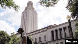 Seorang mahasiswa berjalan melewati menara jam di kampus University of Texas di Austin, Texas, 23 Juni 2016 (Foto: dok). Undang-undang baru yang mulai berlaku bulan lalu di Texas, mengizinkan siapa pun yang mempunyai izin membawa senjata dengan tersembunyi, diperbolehkan membawa senjata api ke kampus.