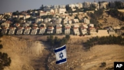 FILE - An Israeli flag is seen near the West Bank Jewish settlement of Maaleh Adumim on the outskirts of Jerusalem in a Sept. 7, 2009, photo.