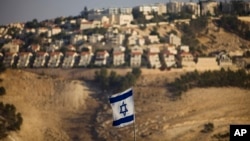 FILE - An Israeli flag is seen near the West Bank Jewish settlement of Maaleh Adumim on the outskirts of Jerusalem in a Sept. 7, 2009, photo. U.S. officials have grown increasingly frustrated with the Israeli government ignoring American official criticism of settlements in the occupied territories.