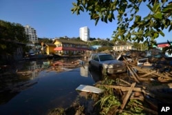 A car is surrounded by debris in a flooded street after an earthquake-triggered tsunami hit Concon, Chile, Sept. 17, 2015.