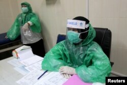 Para petugas medis di sebuah puskesmas di Aceh mengenakan jas hujan untuk melayani pasien di tengah wabah virus corona (COVID-19), 8 April 2020. (Foto: Antara via Reuters)