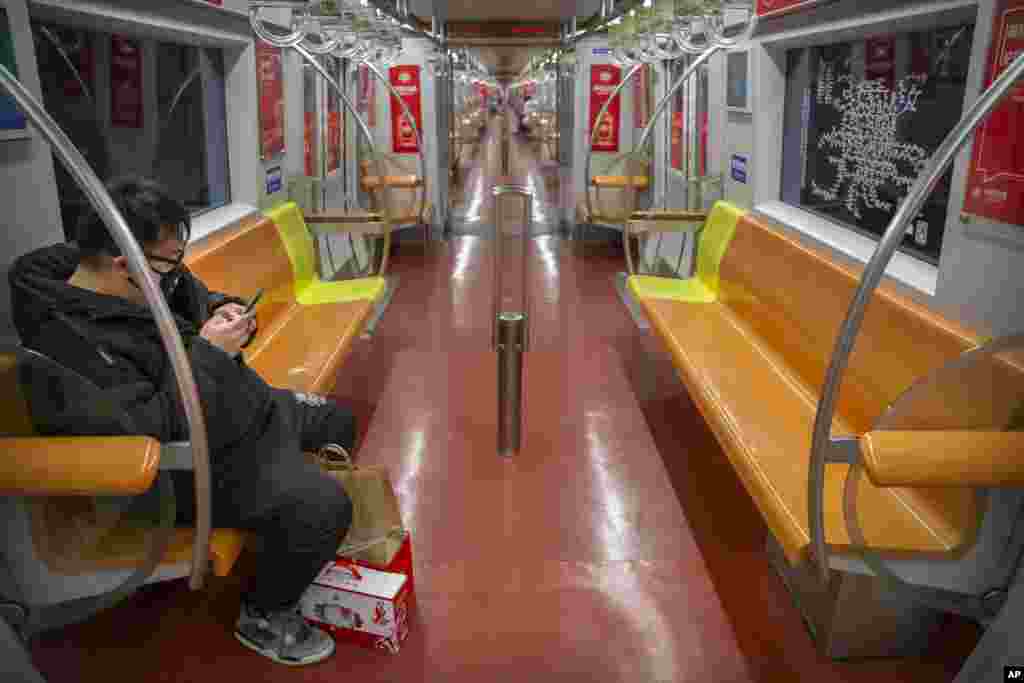A man wearing a face mask rides a nearly empty subway train in Beijing, China.