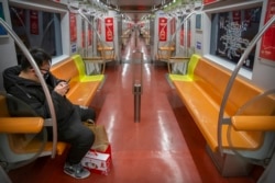 一个戴着口罩的乘客独自在北京地铁里
