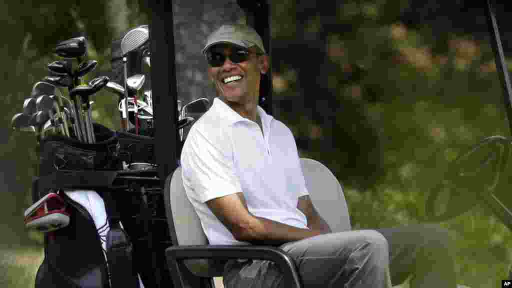 Le président américain Barack Obama assis dans une voiture de golfe, 15 août 2015.