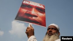 FILE - A demonstrator holds a placard during a protest against what demonstrators say is the killing of the Rohingya people in Myanmar, in New Delhi, India, Sept. 13, 2017.