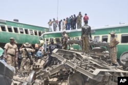 Pejabat dan relawan Pakistan berupaya mengevakuasi korban di lokasi kecelakaan kereta api di Rahim Yar Khan, Pakistan, 11 Juli 2019.