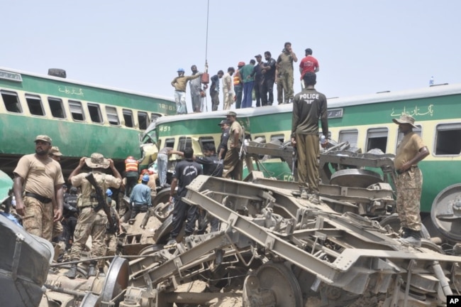 Pejabat dan relawan Pakistan berupaya mengevakuasi korban di lokasi kecelakaan kereta api di Rahim Yar Khan, Pakistan, 11 Juli 2019.