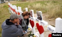 지난달 미국 텍사스주 서덜랜드스프링스의 제일침례교회에서 총기 난사 사건이 발생해 26명이 사망했다. 추모객들이 희생자들을 기리기 위한 임시 기념비를 찾았다.