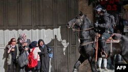 Women react as an Israeli mounted policeman disperses Palestinian protesters on December 9, 2017, in East Jerusalem.