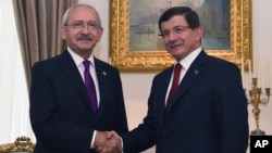 Turkish Caretaker Prime Minister and leader of the Justice and Development Party (AKP) Ahmet Davutoglu (R) shakes hands with the leader of the main opposition Republican People's Party (CHP) Kemal Kilicdaroglu, in Ankara, Turkey, Aug. 10, 2015.