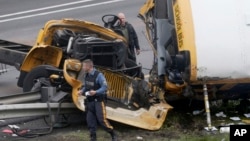 Emergency personnel work at the scene of a school bus and dump truck collision, injuring multiple people, on Interstate 80 in Mount Olive, N.J., May 17, 2018. 