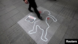 A pedestrian walks over an illustration to draw attention to domestic violence against women, on International Women's Day, file photo. 