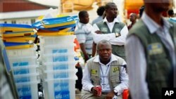 Electoral commission president Daniel Ngoy Mulunda sits amidst ballot boxes at the Fikin grounds used as a central tallying point in Kinshasa, Democratic Republic of Congo.