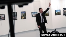 A man identified as Mevlut Mert Altintas shouts after shooting Andrei Karlov, the Russian Ambassador to Turkey, at a photo gallery in Ankara, Turkey, Dec. 19, 2016. 