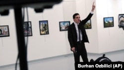 A man identified as Mevlut Mert Altintas shouts after shooting Andrei Karlov, the Russian Ambassador to Turkey, at a photo gallery in Ankara, Turkey, Dec. 19, 2016. 
