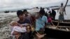 A Rohingya ethnic minority from Myanmar carries an elderly woman as they alight from a local boat on which they crossed a river, after crossing over to the Bangladesh side of the border near Cox's Bazar's Dakhinpara area, Saturday, Sept. 2, 2017.