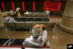 Chinese investors monitor stock prices at a brokerage house in Beijing, Aug. 24, 2015.