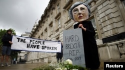 A protester wearing a Theresa May mask is seen the day after Britain's election in London, June 9, 2017. 