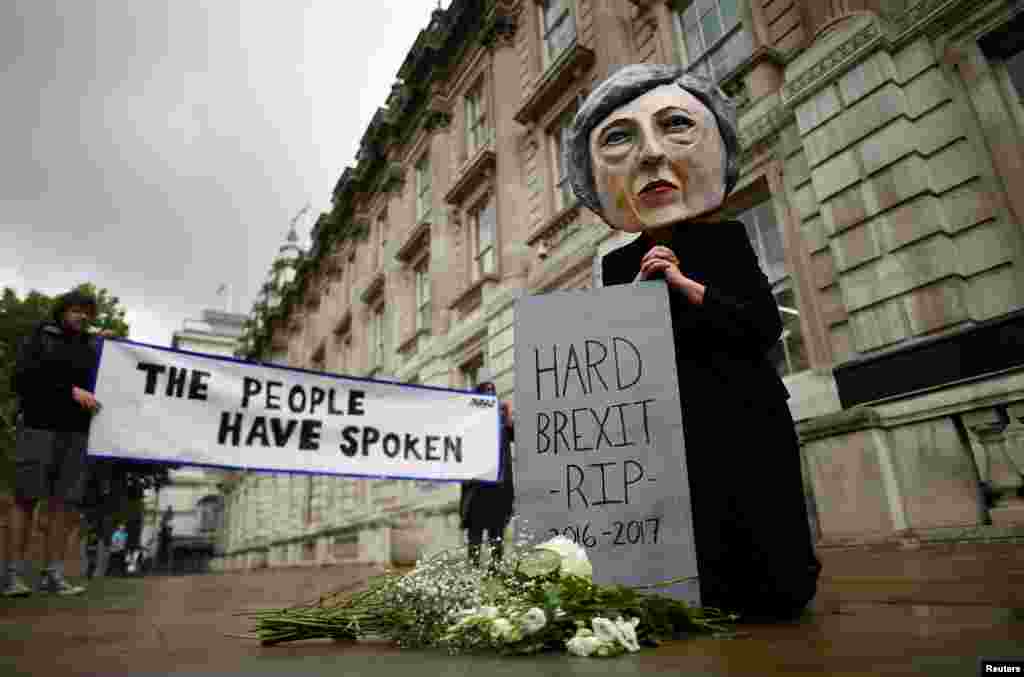 Seorang pengunjuk rasa mengenakan topeng PM Inggris, Theresa May, tampak pada hari pelaksanaan pemilu di London, Inggris.