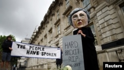 英国选举后，伦敦的一名抗议者头戴特雷萨.梅的面具（2017年6月9日） 