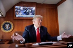 President Donald Trump, on board Air Force One, gestures while watching a live television broadcast of the Senate confirmation vote of Supreme Court nominee Brett Kavanaugh, Oct. 6, 2018.