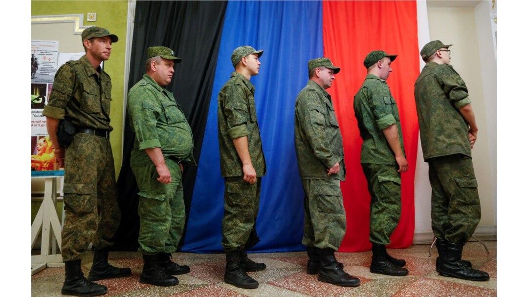 Militan Republik Rakyat Donetsk yang memproklamirkan diri, antre di pusat informasi untuk memberikan suara dalam pemilihan parlemen Rusia melalui sistem online di kota Donetsk yang dikuasai pemberontak, Ukraina 17 September 2021. (REUTERS/Alexander Ermochenko)