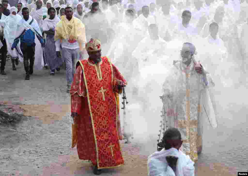 Dua pendeta Kristen Ortodoks Ethiopia memberkati warga di jalan-jalan dengan dupa yang menurut keyakinan mereka akan menjauhkan penyakit virus corona (Covid-19), di Addis Ababa, Ethiopia.