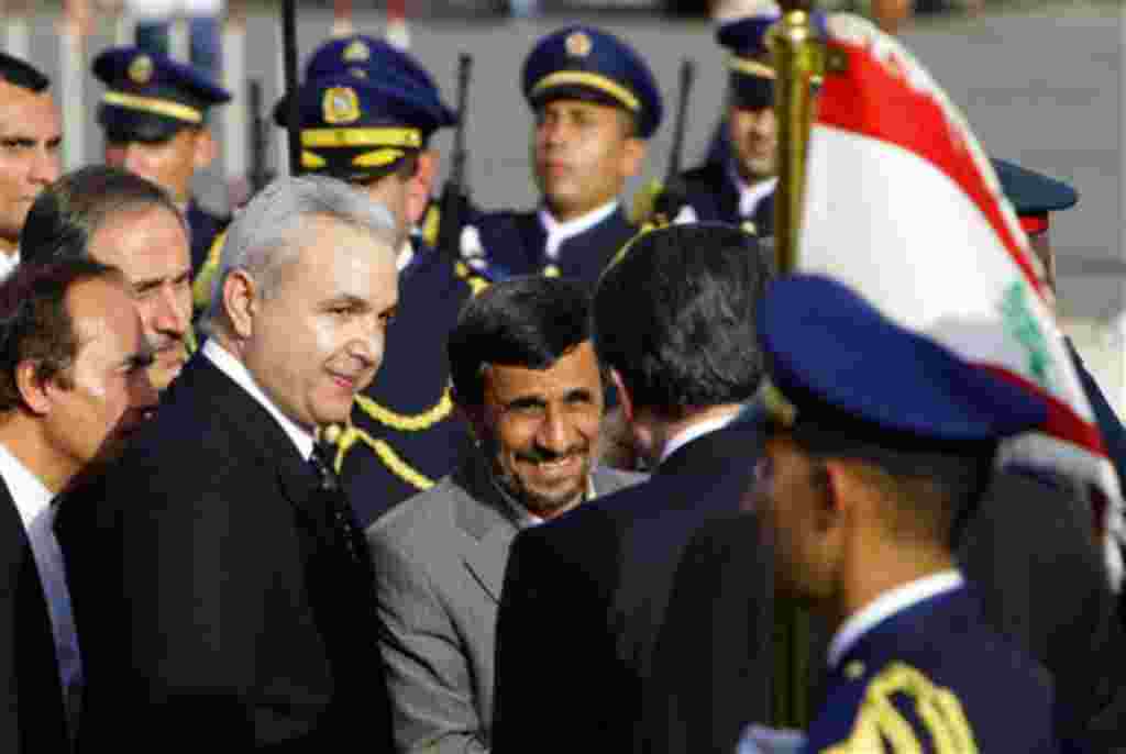 Iranian President Mahmoud Ahmadinejad, center, arrives with Lebanese Defense Minister Elias Murr, left, to lay a wreath at the Martyrs' statue in downtown Beirut, Lebanon, Wednesday, Oct. 13, 2010. Thousands of cheering Lebanese welcomed Iranian President