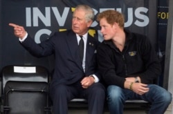 Pangeran Charles (kiri) dan putranya Pangeran Harry selama Pertandingan Invictus di Pusat Atletik Lembah Lee di London utara 11 September 2014. (Foto: REUTERS/Neil Hall)