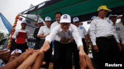 Pemimpin oposisi Kamboja, Sam Rainsy (tengah) menyalami para pendukungnya di provinsi Kampong Speu (20/7).